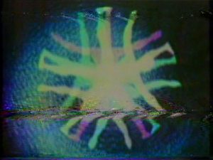 1970s-era video graphic with the outline of a person with outstretched arms repeated in a radially symmetric pattern