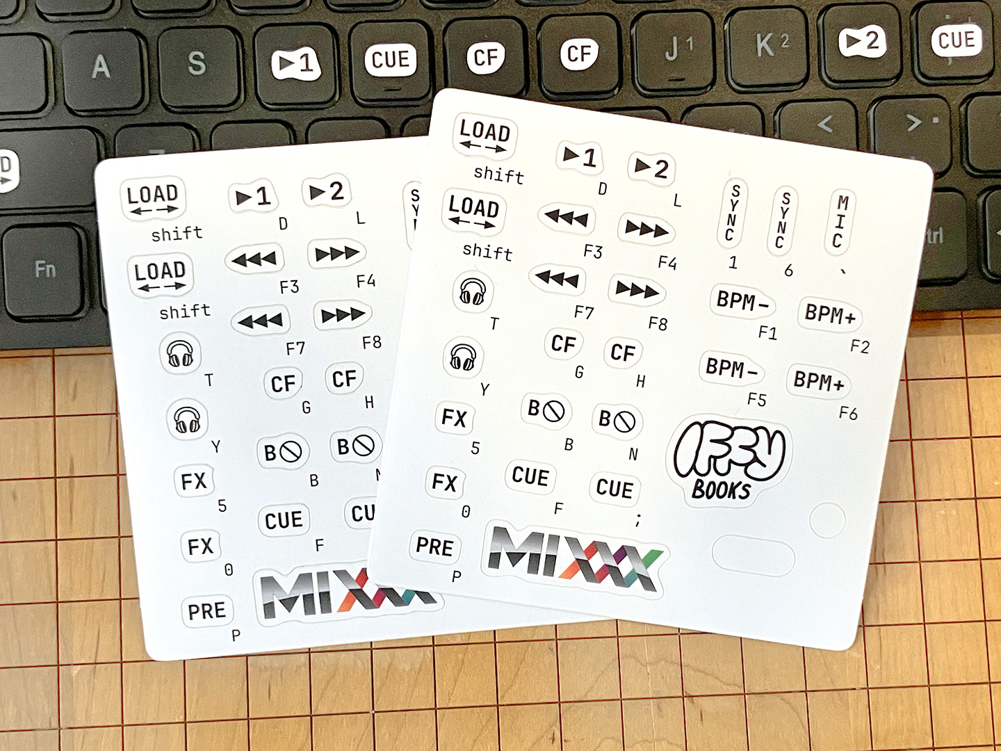 Two die-cut sticker sheets with stickers that can turn a USB QWERTY keyboard into a DJ controller for the free program Mixxx