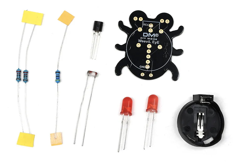 Photo of a soldering kit with a circuit board shaped like a weevil, three resistors, two LEDs, a transistor, a photoresistor, and a battery clip.