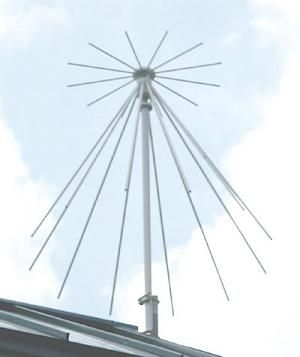 Photo of a discone antenna mounted on a roof, with metal rods extending down in a cone shape. Source: https://wiki.ham.hu/index.php?title=F%C3%A1jl:Discone_teton.jpg
