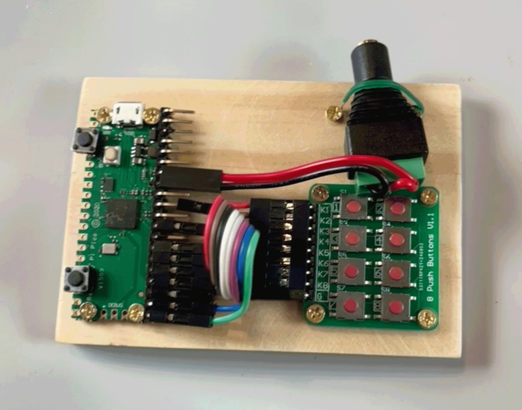 A handmade audio sampler with a Pi Pico board, a 2x4 push button keypad, and a 3.5mm audio output jack