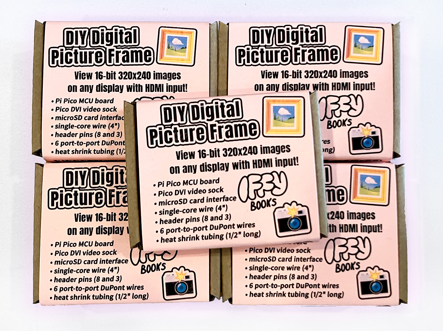 Five DIY Digital Picture Frame kits from Iffy Books in small cardboard boxes with pink wraparound labels. The label says "View 16-bit 320x240 images on any display with HDMI input!" followed by a list of included parts